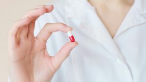 A doctor holds a pill, explaining what to avoid when taking Brilinta