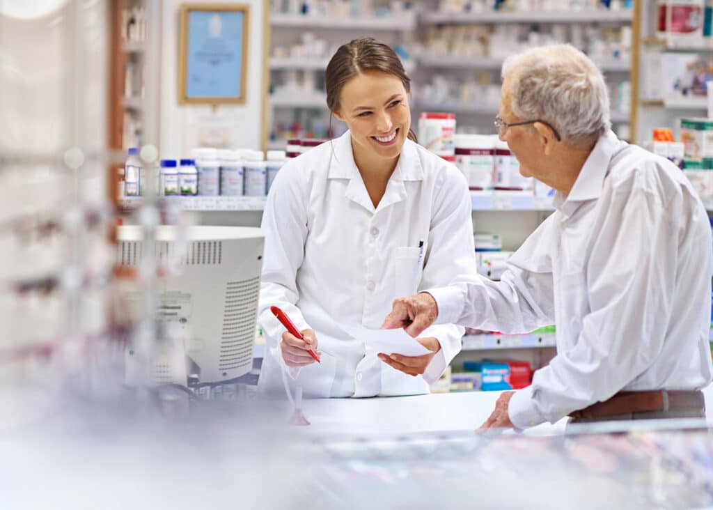 A pharmacists helps an elderly man determine how to treat his winter ailments with the proper prescriptions.