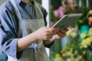 a business owner researches prescription access on her tablet in her shop.